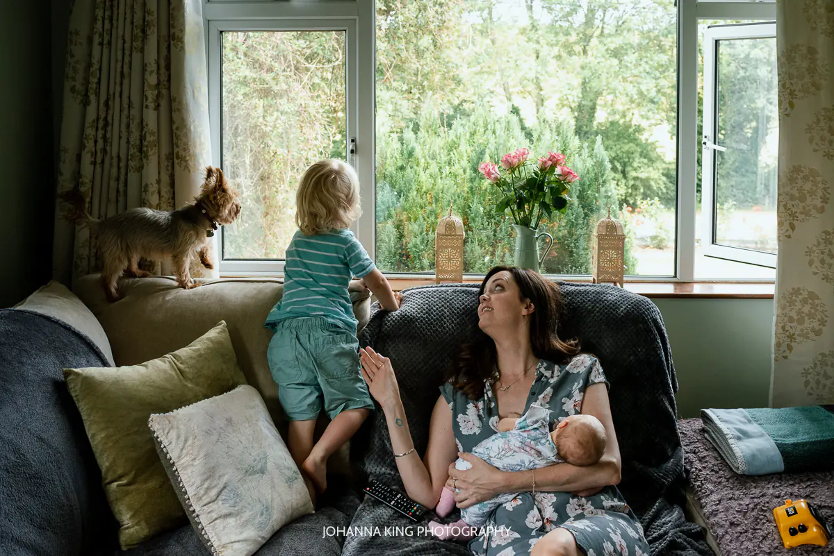 Tired mother sitting quietly, not forcing a smile, reflecting on real emotional support