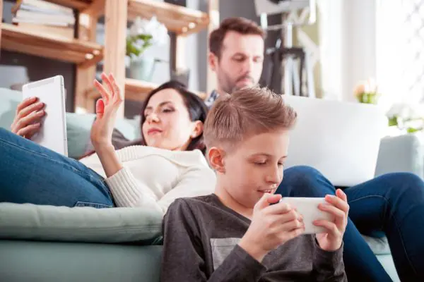 Parent and young child sitting together watching a tablet screen, co-viewing content together