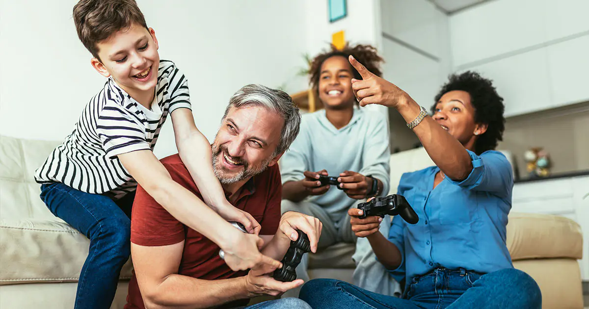Parent and child sitting together on a couch watching a video call with a grandparent on a tablet