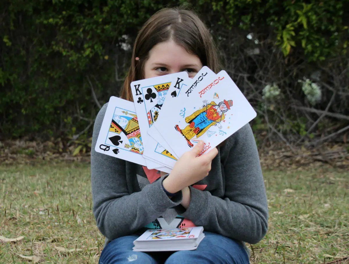 Young child holding Uno draw two card while playing card game with family