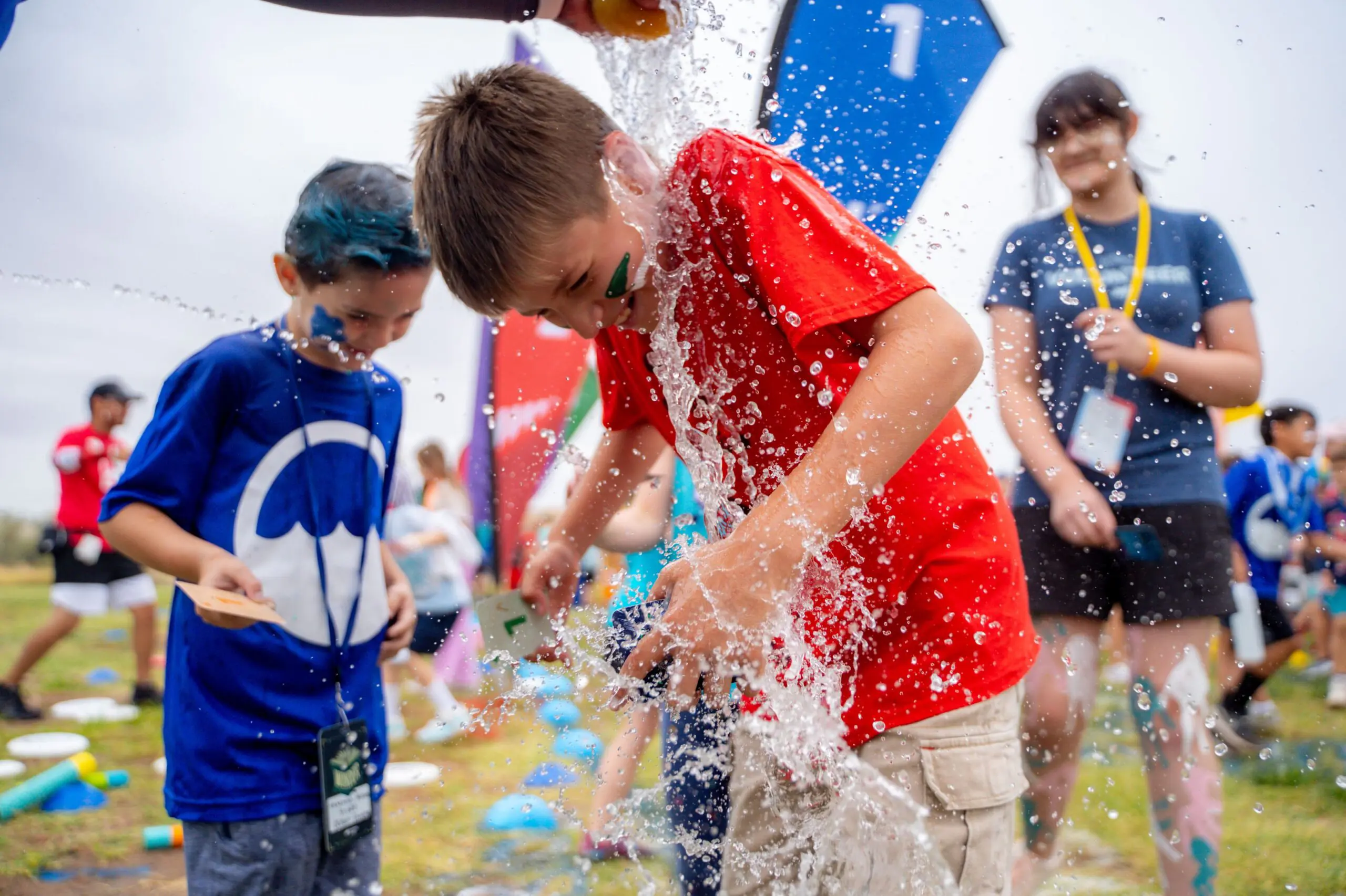 Kids running sponge relay race between two buckets