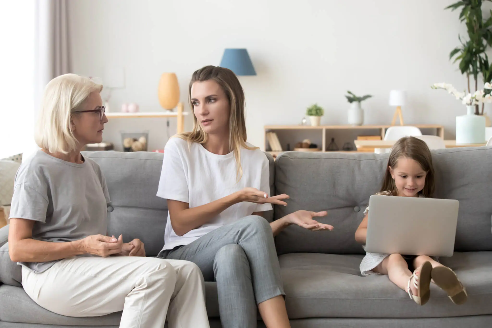Grandmother and mother discussing a child's outfit, representing generational parenting differences