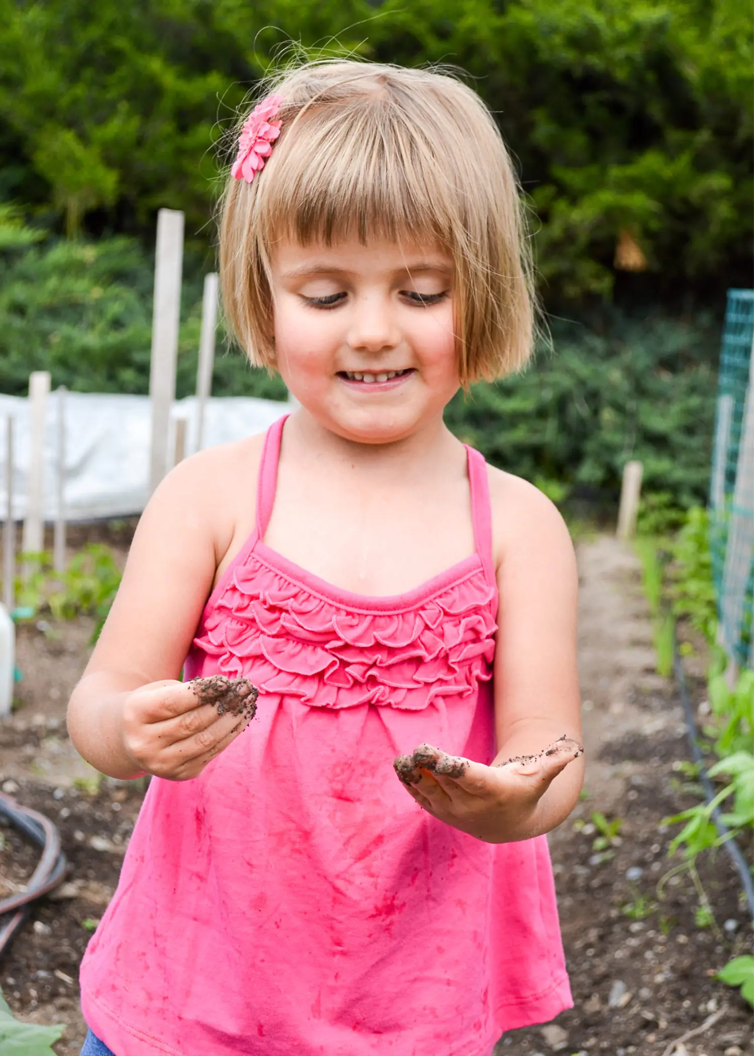 Child playing outdoors in a pink dress at a birthday party