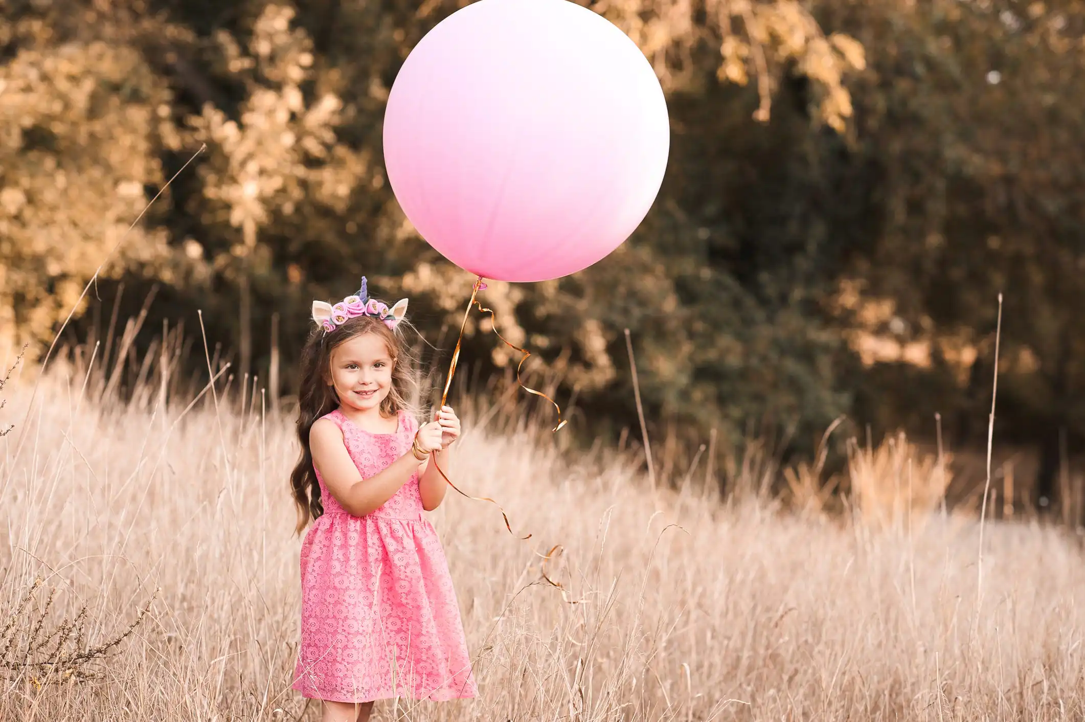 Toddler girl reaching for a pink toy over other colored options